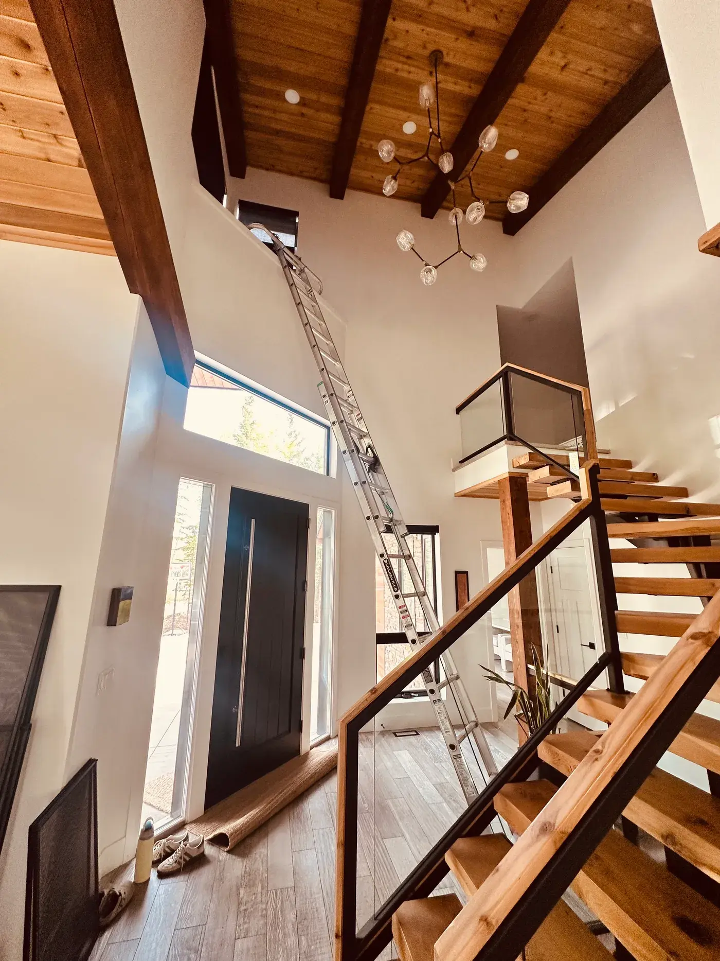 Peace Home Services cleaning vaulted interior windows from a ladder