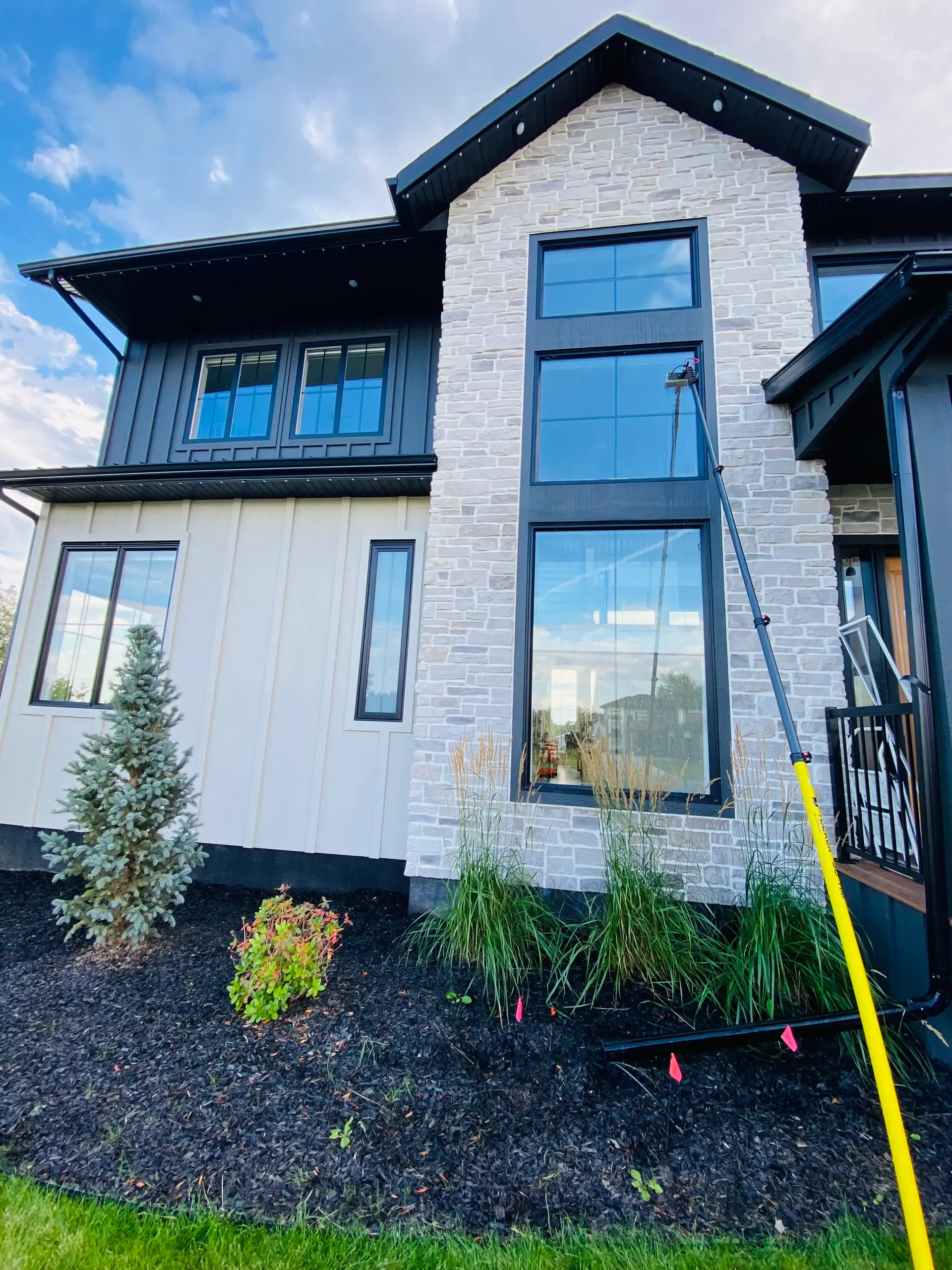 Linnae using water-fed pole for safe exterior window cleaning in Grande Prairie