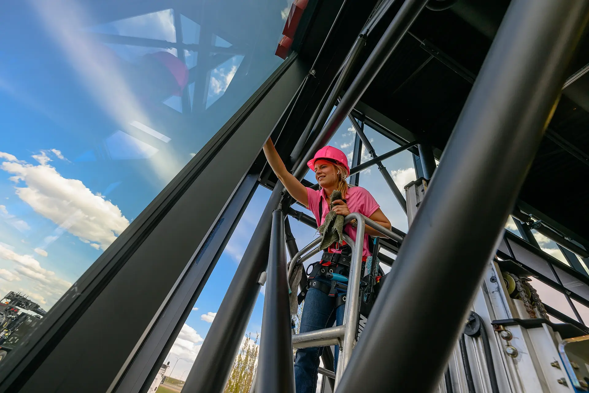 Linnae cleaning commercial windows from a lift in Grande Prairie - Peace Home Services