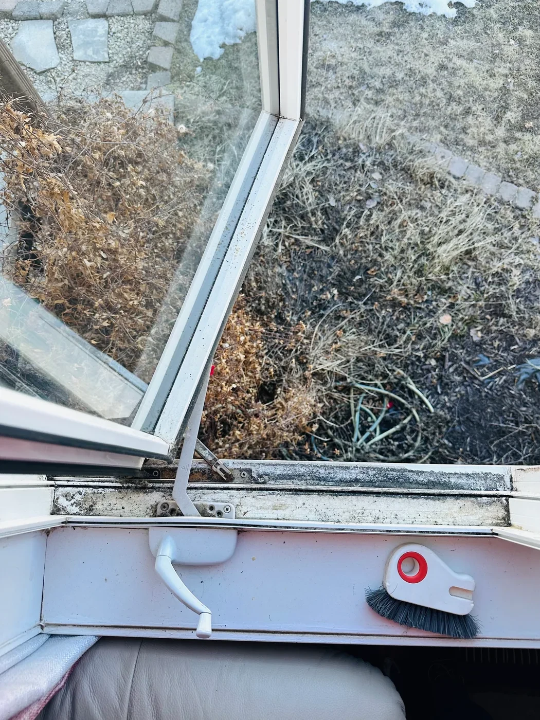 Window track full of dirt and debris before cleaning