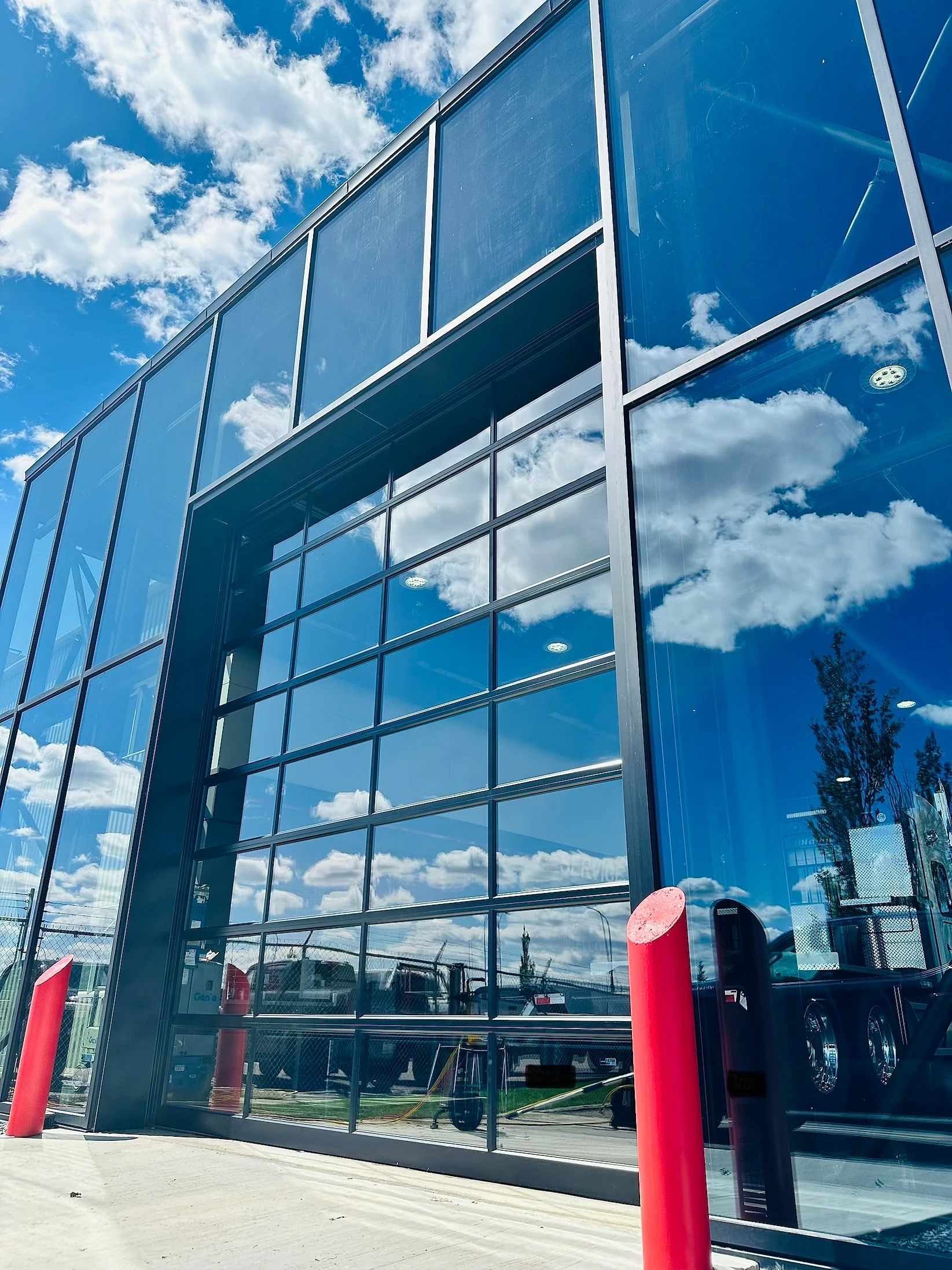 Streak-free commercial glass mirroring the sky after professional cleaning